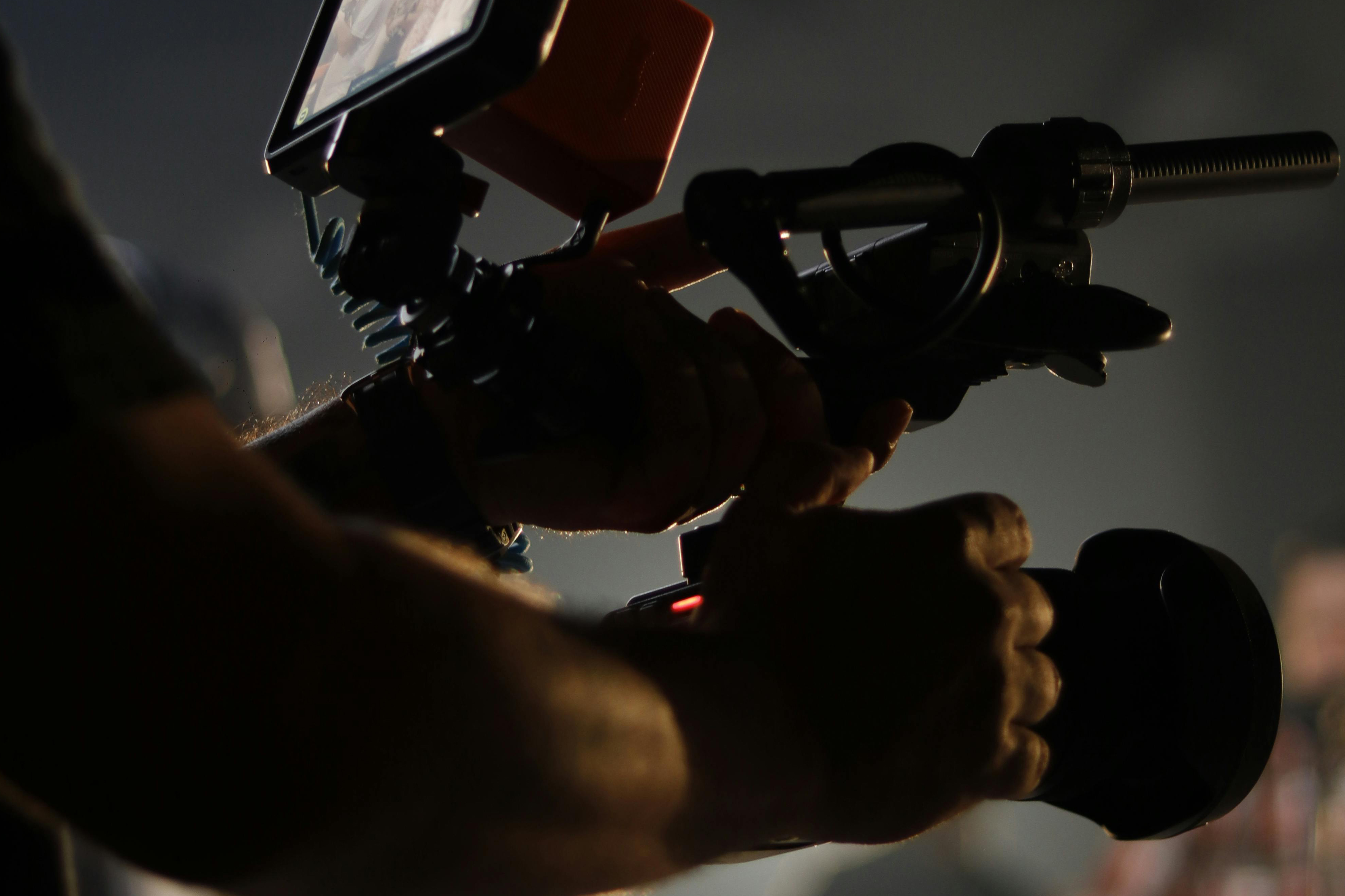 Close-up of hands gripping a handheld camera rig